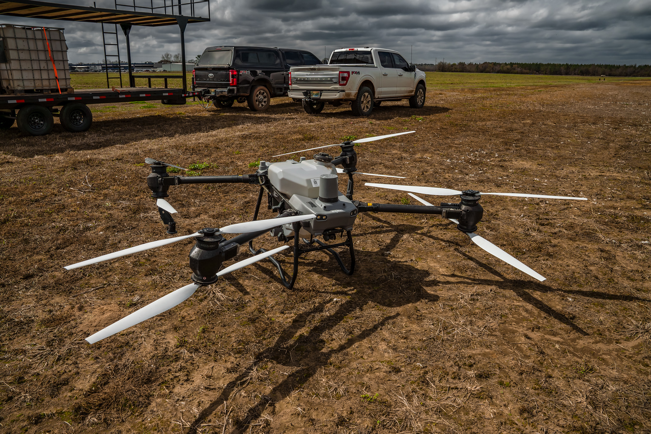 The agricultural spray drone staged on the ground before takeoff