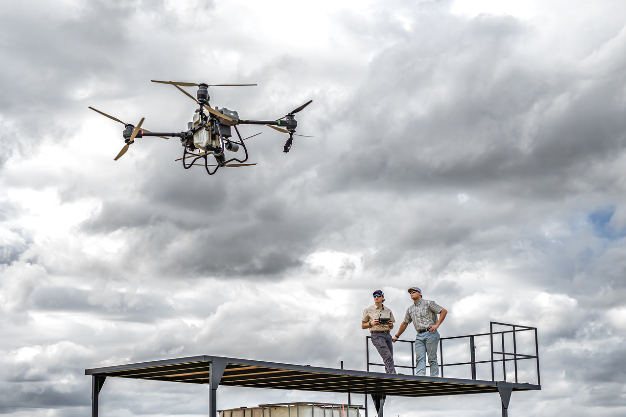 Elevated Ag agricultural spray drone hovering above the launch platform