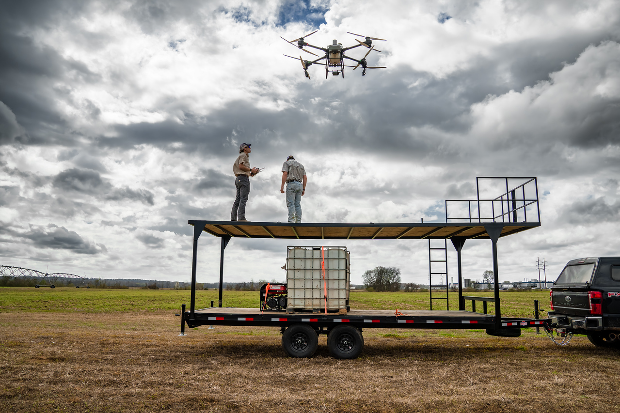The full Elevated Ag field rig — trailer, tank, generator, and drone overhead