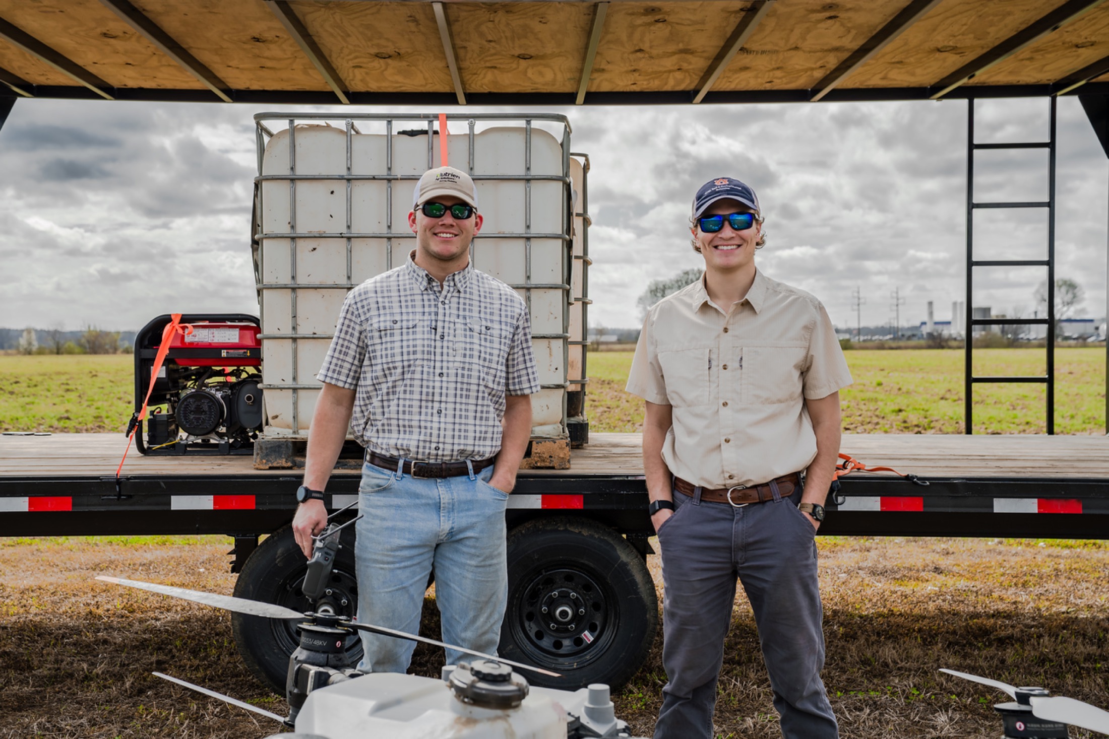Elevated Ag founders portrait in front of field trailer and equipment