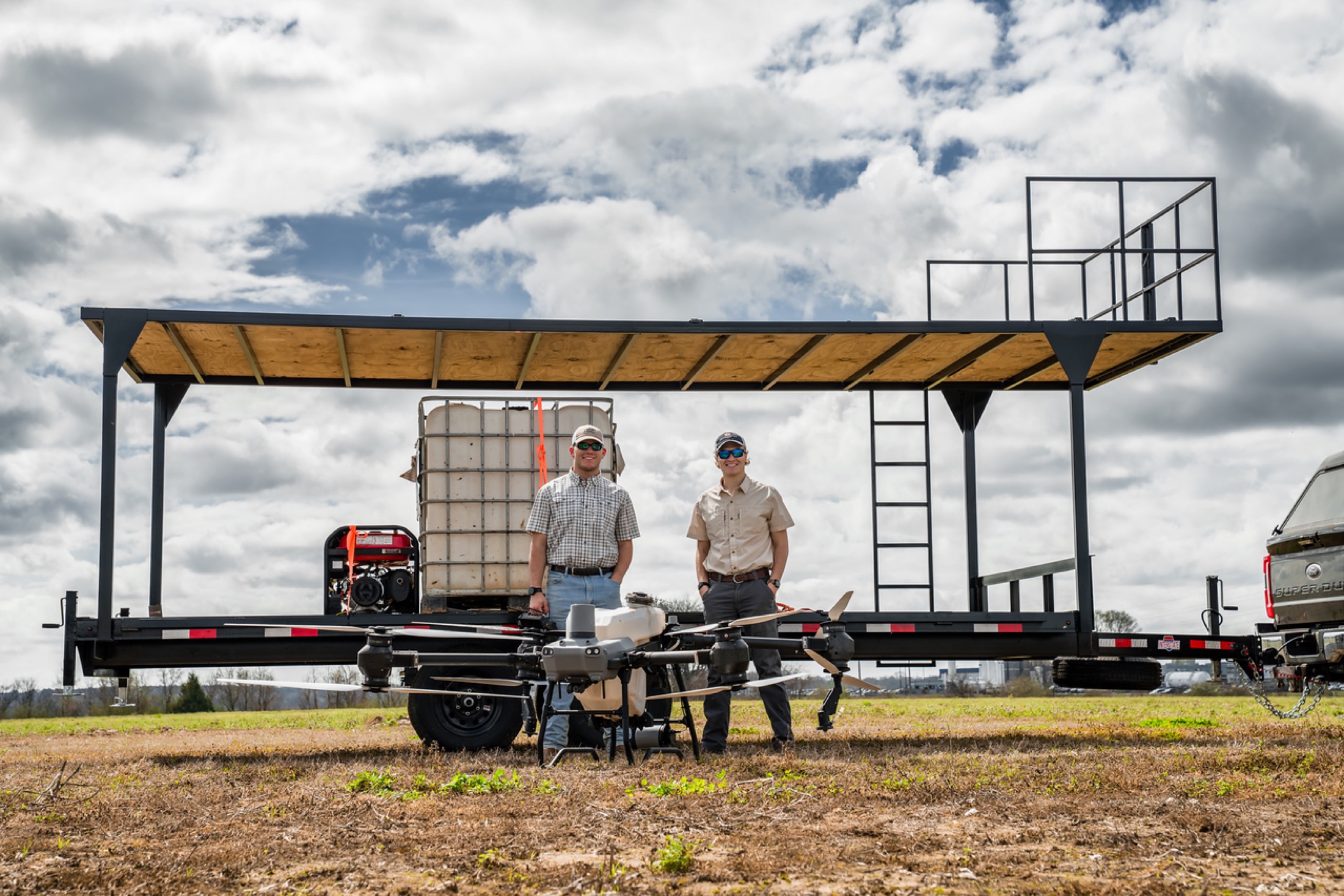 Founders of Elevated Ag with field rig and tank setup