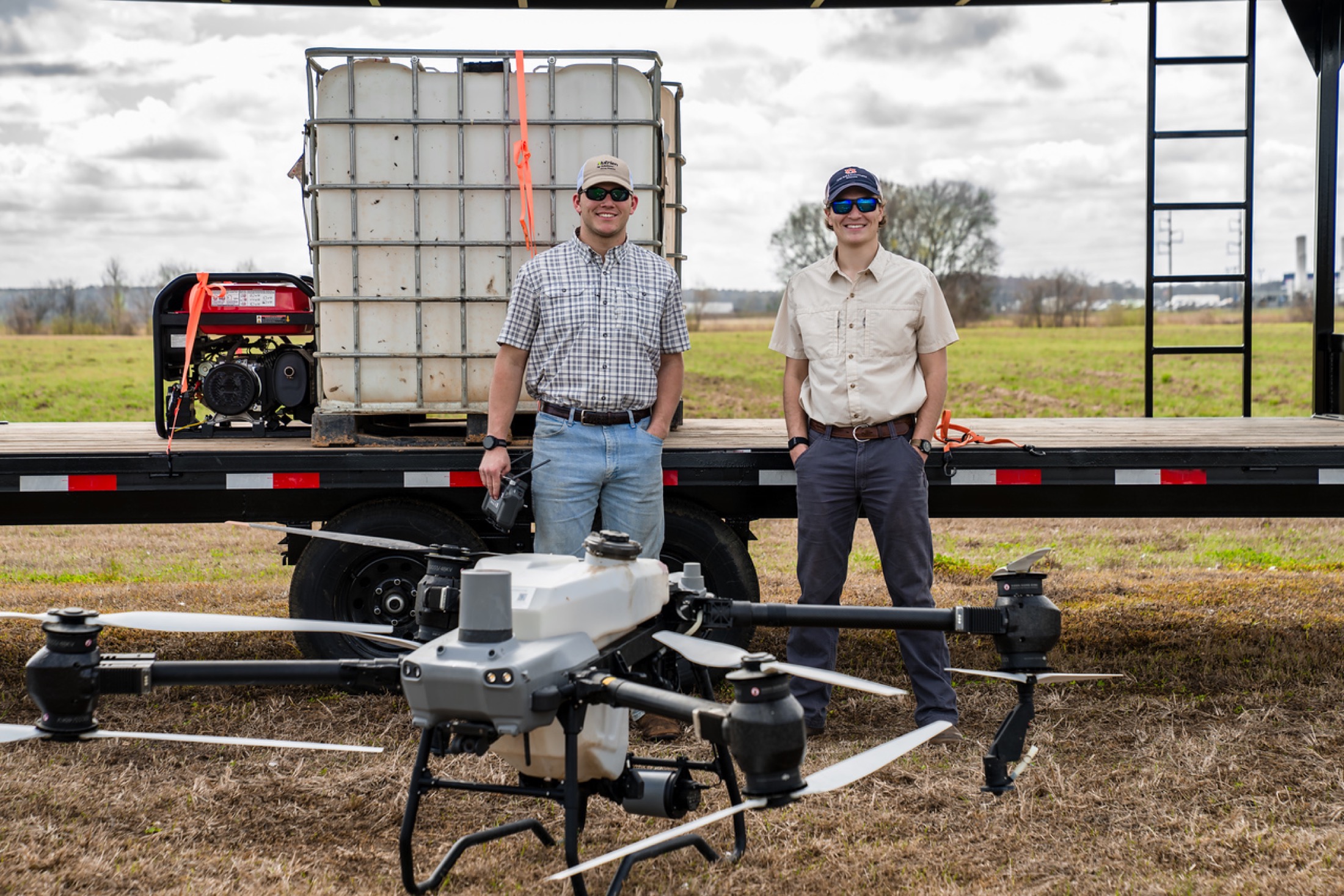 Wide field shot of Elevated Ag founders, trailer, and spray drone
