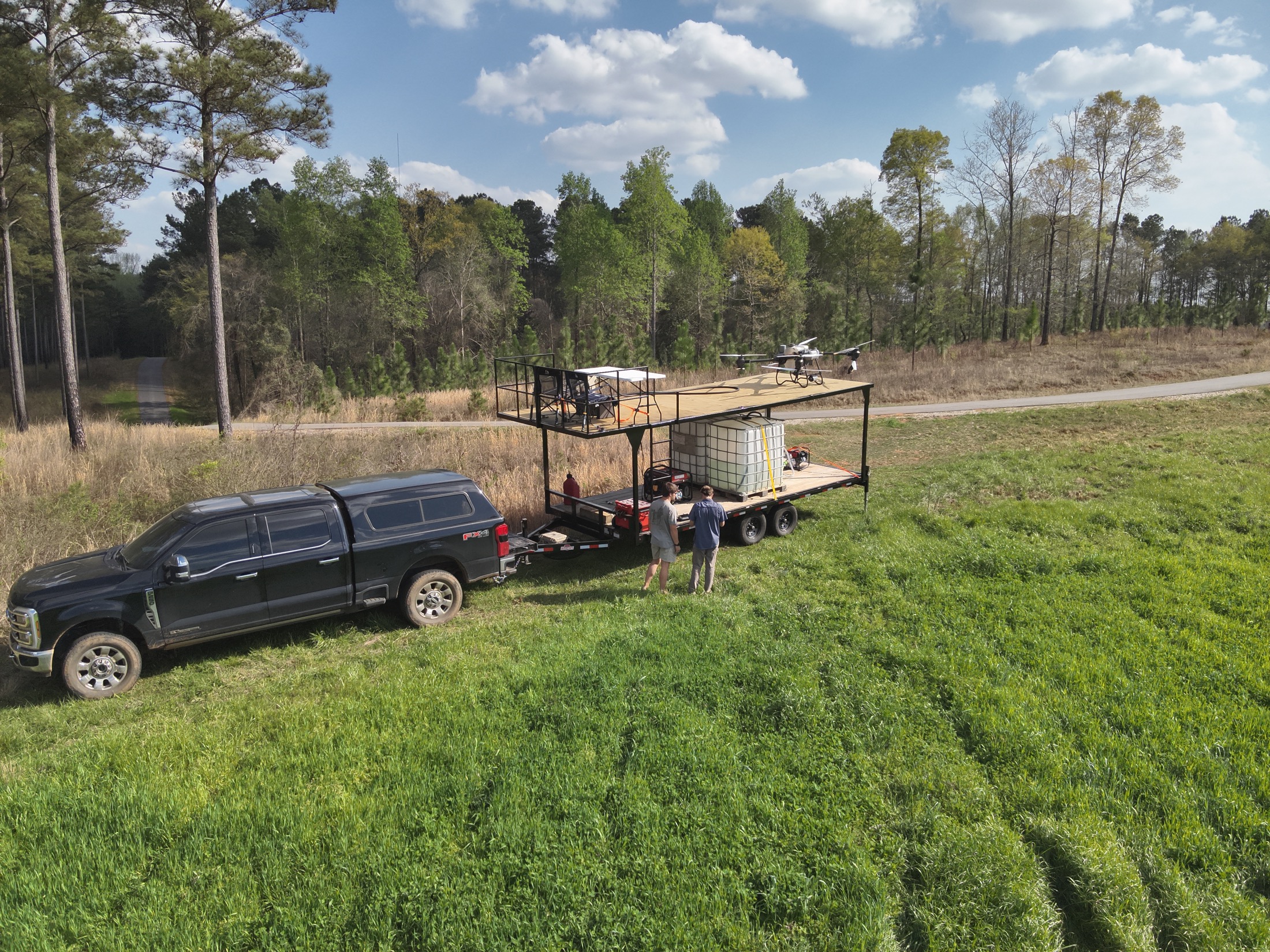 Aerial view of Elevated Ag spray trailer staged beside Alabama timberland